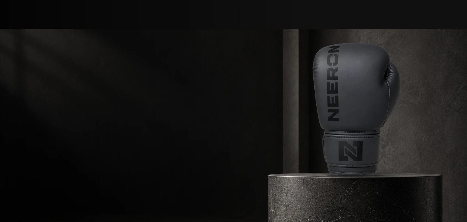 Black NEERON boxing glove on a charcoal stone plinth